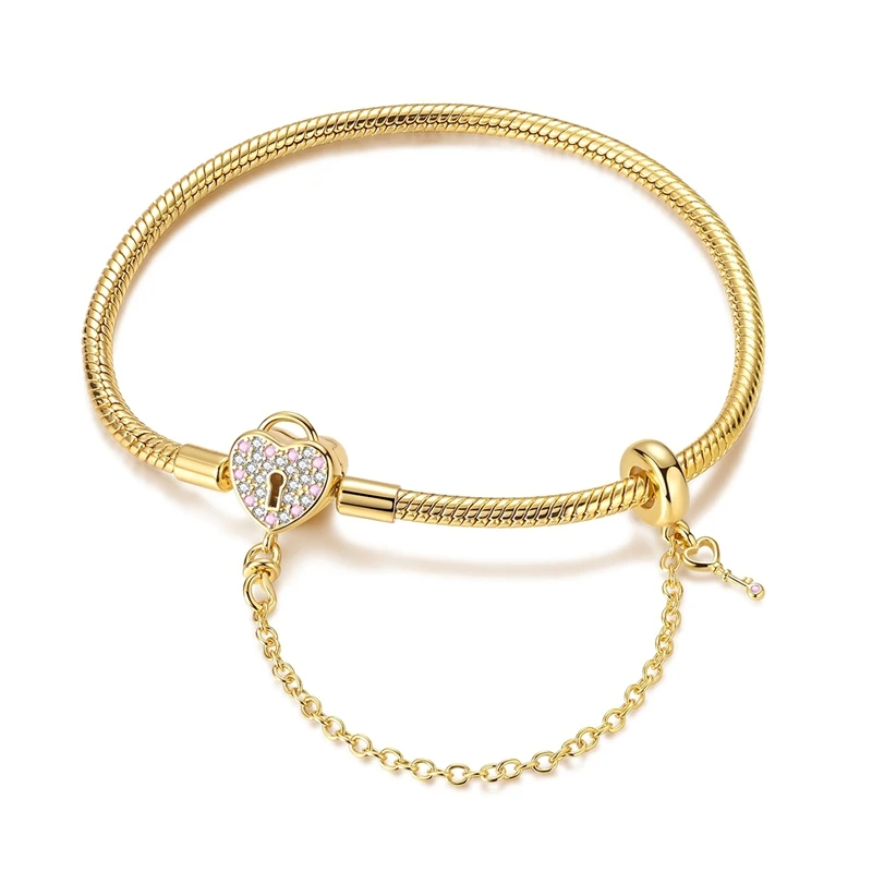 Pulseira dourada com cadeado de coração cravejado de zircónias e pingente de chave.