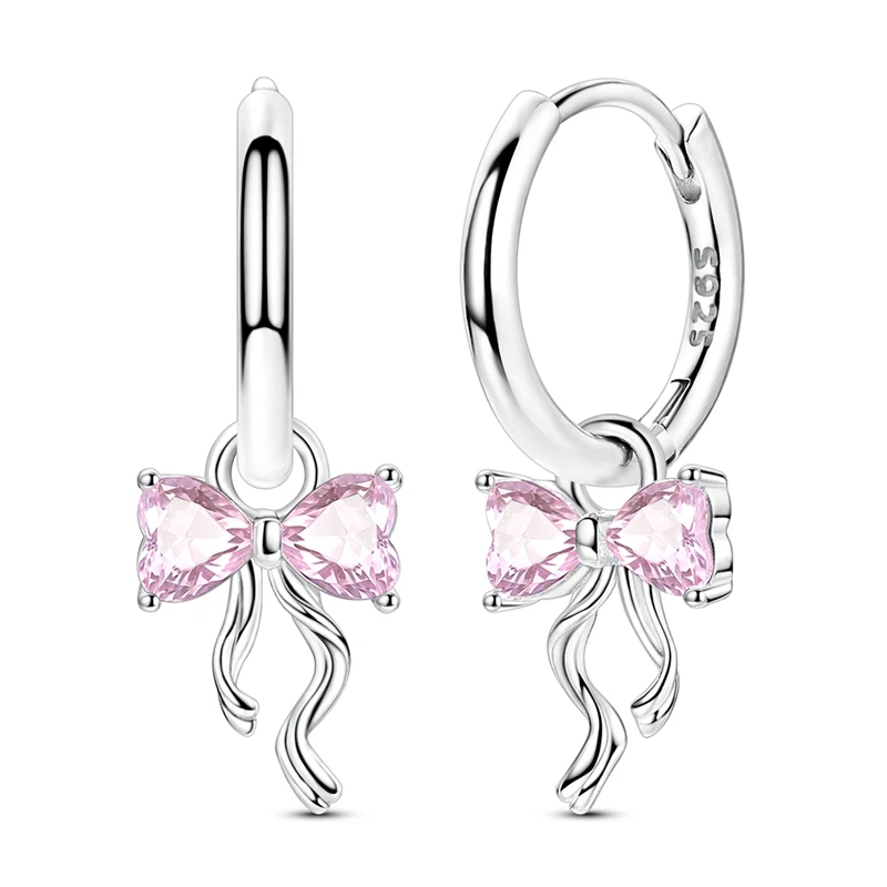 Brincos de argola huggie em prata com pendente laço e pedras coração rosa.
