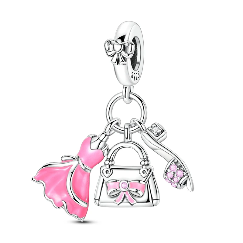 Pingente charm em prata com miniaturas de vestido rosa, bolsa com laço e sapato de salto alto com pedras rosa.