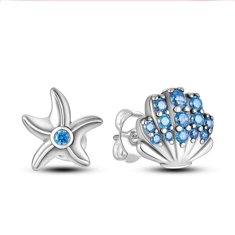 Brincos stud assimétricos em prata: estrela-do-mar com zircónia azul e concha cravejada de zircónias azuis.